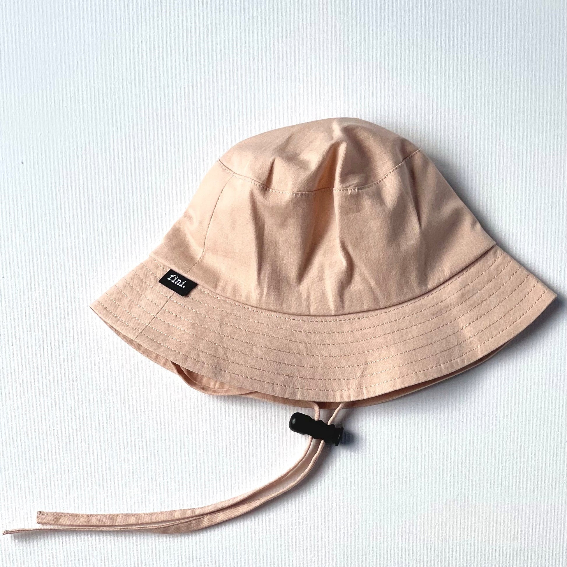 WS_available now_FINI. HAT: fini. bucket hat - light pink-fini. the label